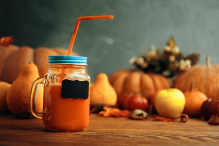 Pumpkins juice in bottles with pumpkins. Cup of pumpkin juice, pumpkins on wooden table. Cup of pumpkin juice, pumpkins and on old wooden table..の写真素材