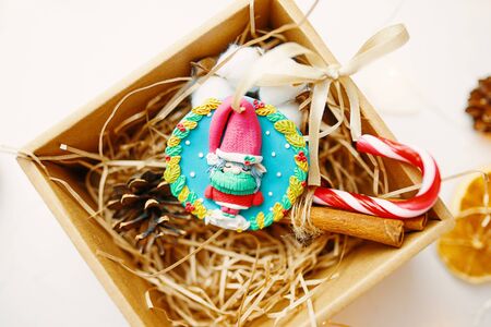 Christmas time. Process of packing gifts for holidays. Cookies and toys and fluff lie beautifully in a gift box.の写真素材