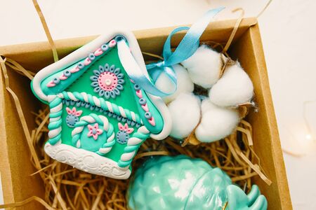 Christmas time. Process of packing gifts for holidays. Cookies and toys and fluff lie beautifully in a gift box.の写真素材
