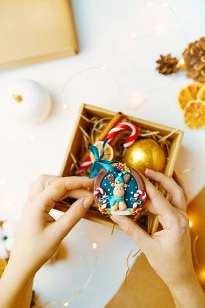 Process of packing gifts for holidays. Woman puts sweets in a box for Christmas.の写真素材