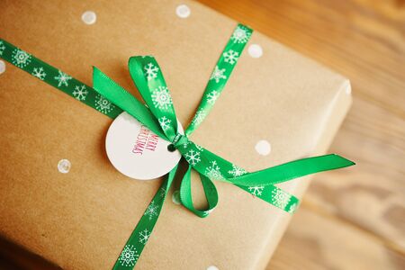Little tag with Christmas wishes and gifts. Label on the gift box that says Merry Christmas.の写真素材