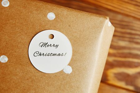 Little tag with Christmas wishes and gifts. A small tag on the gift box that says Merry Christmas.の写真素材