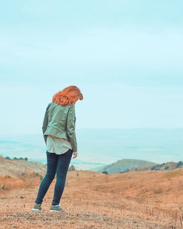 Beauty woman outdoors enjoying nature. Pretty young woman in field at bad weather.の写真素材