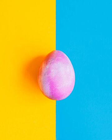Cosmic galactic Easter egg on blue and yellow pastel backgroundの写真素材