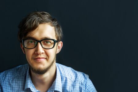 Man in glasses. Confident boy in eyeglasses looking at camera and smiling.の写真素材