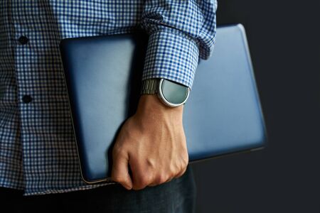 Laptop in hand. Notebook in arm with smartwatch.の写真素材