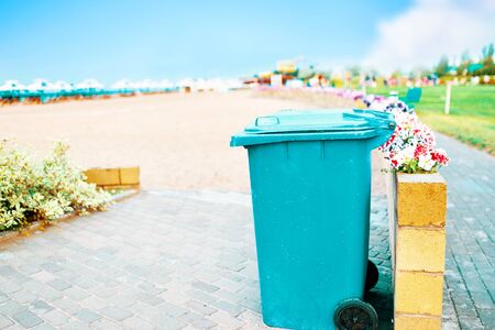 Trashcan on the beach. Blue waste canister, by the sea.の写真素材