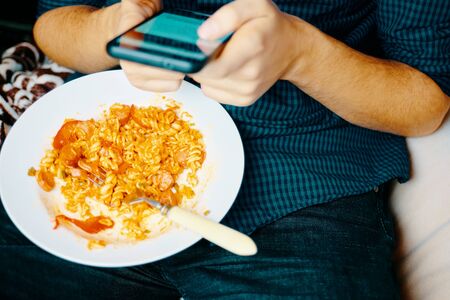 Using smartphone. Close-up Mans hands use pointing finger Mobile smart Phone on Food table, technology and home concept.の写真素材