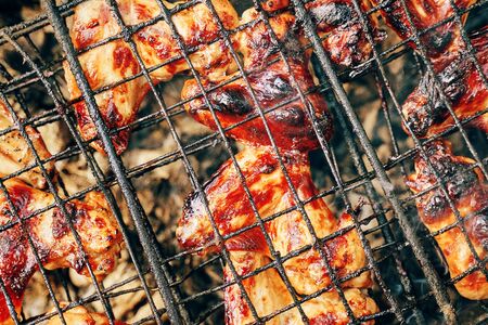 Fried food. Grilled chicken wings on the flaming grill.の写真素材