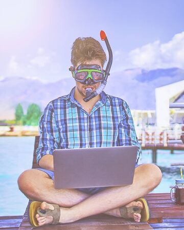 The concept of a working man on vacation, a man in an underwater mask at sea.の写真素材