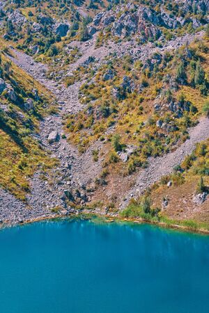 Lake in the mountains. Rocky lacustrine shore in the upland. Happy international mountain day.の写真素材