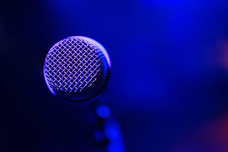 Microphone on colorful background. Close-up of retro microphone at concert.