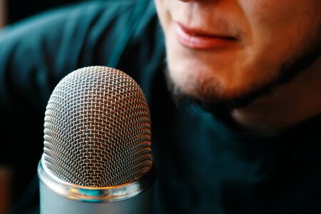 A person is broadcasting on the air on a microphone. Podcast studio.