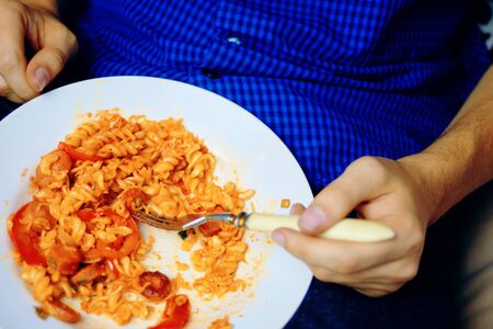 Man eats. Human during a break at work, eating pasta.の写真素材