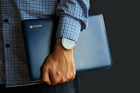 Bishkek, Kyrgyzstan - June 6, 2019: Man holding a Asus Chromebook.のeditorial素材