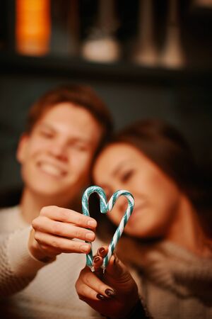 Couple on Valentines day. A man and a woman make a heart out of candy.の写真素材