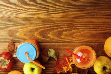 Glass of fresh pumpkin smoothie on wooden background with apples. Flat lay with copy spaceの写真素材
