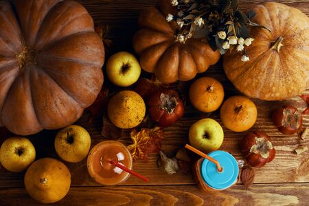 Healthy pumpkin smoothie in mugs with tubes on rustic background with apples. Flat layの写真素材