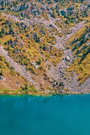Lake in the mountains. Rocky lake shore in the mountains. Happy international mountain day.の写真素材
