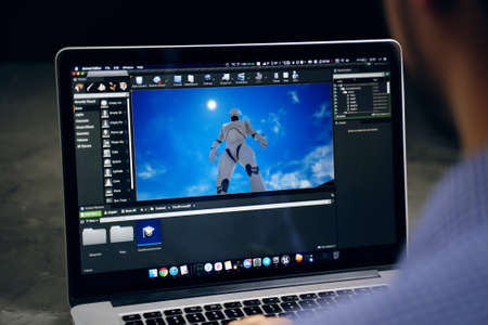 Game developer creating on main screen of unreal engine software on apple macbook macOS operation...