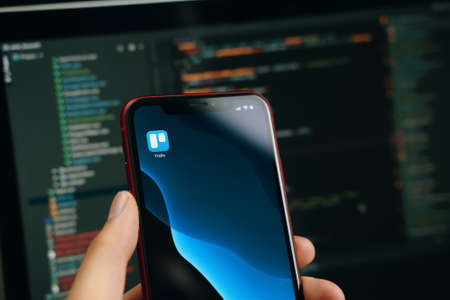 Woman is going to plan their day and projects on Apple iPhone smartphone in the task manager app Trello, a collaboration tool that organizes your workflow. Bishkek, Kyrgyzstan - March 14 2020.のeditorial素材