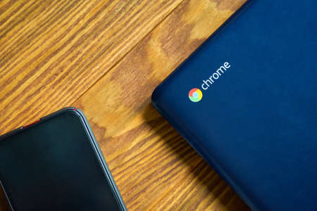 Blue Asus Chromebook and Iphone on a wooden table, top view. Bishkek, Kyrgyzstan - June 8, 2019.のeditorial素材