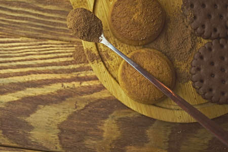 Oatmeal cookies and topping on a tray. Spoon with spices or chocolate chips. Baking on a wooden background. The concept of Christmas, Thanksgiving and Halloween.の写真素材