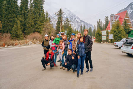 Tourists arrived at hotel after hike in mountains. Group photo of hikers. Resort area for picnics. People on vacation in forest. International mountain day. Bishkek, Kyrgyzstan - April 9, 2019.のeditorial素材
