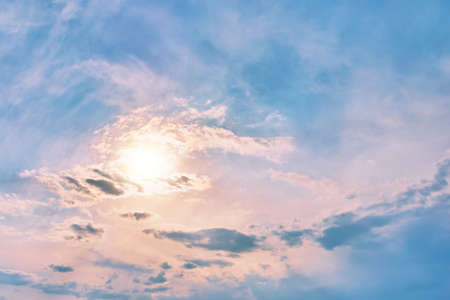 Sun in the sky. Rays of sunshine breaks through the clouds. Overcast sky. Sunset colored clouds.の写真素材