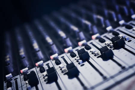 Sound recording directors console. Remote audio engineer. Many buttons of grey audio mixer board console for sound producer. Music equipment. Close-up. Mixer for musician DJ. Night club concept.の写真素材