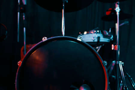 Drums over neon light background. Drum kit on stage for concerts and performances. Musical percussion instruments. Creating and performing musical compositions. Night club concept.の写真素材