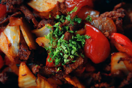 Fried food. Cooked meat with vegetables and salad. Close up. Lamb or beef with sweet peppers, onions and herbs. Seasonings and spices. Dish from the menu of cafe or restaurant of Oriental cuisine.の写真素材