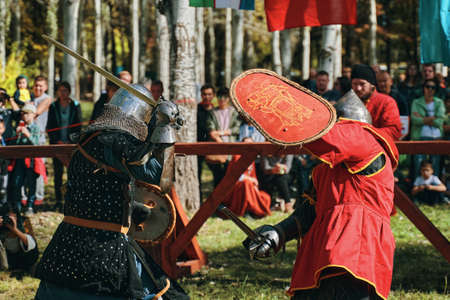 An epic battle of knights in armor and helmets. Sword fighting. Reconstruction of medieval battles. Festival of medieval culture. Bishkek, Kyrgyzstan - October 13, 2019のeditorial素材