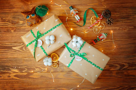 Flat lay of Christmas gifts on wooden table. Boxes in wrapping paper tied with ribbons with...