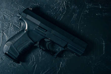 Pistol on green concrete texture table. Ammunition of law enforcement agencies. Handgun for cop. Firearm for defense or attack.の写真素材