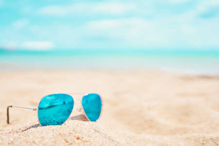 Sunglasses on the beach. Summer holidays at the sea. Vacation on the ocean. Reflection of the beach and sand in glasses.の写真素材