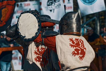Reconstruction of historical events. Festival of jousting tournaments. Two knights with a lion on their clothes are fighting with swords. Bishkek, Kyrgyzstan - October 13, 2019のeditorial素材