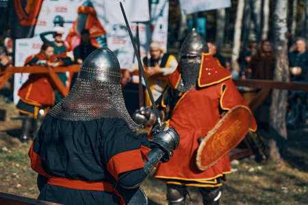 Knights fight with swords and shields in front of the public. Reconstruction of medieval battles during the festival of historical clubs. Bishkek, Kyrgyzstan-October 13, 2019.のeditorial素材