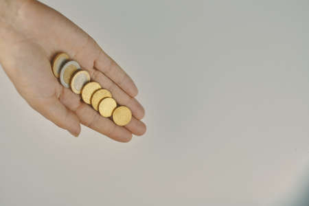 Top view of coins in hand. Expenses and earnings. Concept of alms and donations. Small savings.