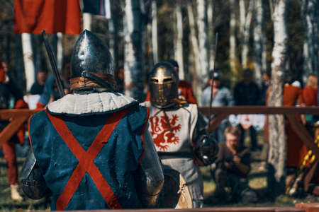 Reconstruction of medieval jousting tournaments. Festival of historical clubs. Two knights fight with swords in front of the audience. Bishkek, Kyrgyzstan - October 13, 2019のeditorial素材