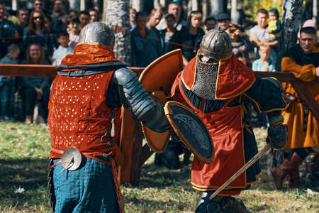 Two knights fight each other with swords. Festival of jousting tournaments. Simulation of medieval battles during the festival of historical clubs. Bishkek, Kyrgyzstan-October 13, 2019.のeditorial素材