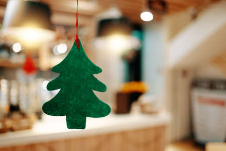 Christmas green felt tree. Concept of new year holidays. Christmas eve tradition. Fir tree on background of home environment. Holiday garlands and decorations.の写真素材
