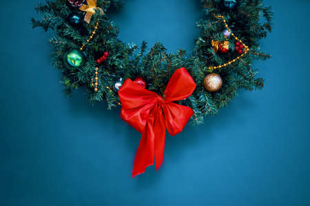 Christmas wreath on wall. New Year atmosphere and aesthetic decorations. Festive ornaments. Background for postcards and posters. Winter holidays.の写真素材