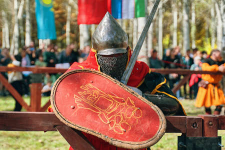 Knight in armor with a shield and a sword. Reconstruction of medieval battles during the festival of historical clubs. Festival of medieval culture. Bishkek, Kyrgyzstan - October 13, 2019のeditorial素材
