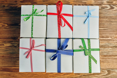 Flat lay of gifts stack. White boxes with ribbons on wooden table. Festive still life. Composition for birthday or new year. Preparing for Christmas.の写真素材