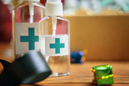 Two sanitizers with turquoise cross on wooden table. Concept of hand hygiene and prevention from viruses and bacteria. Christmas quarantine decorations and antiseptic.の写真素材