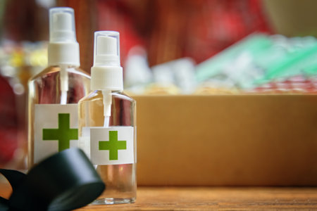 Two alcohol antiseptics with green cross on wooden table. Concept of hand hygiene and prevention from viruses and bacteria.の写真素材