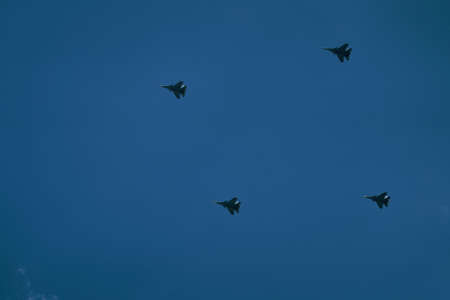 Victory parade of military aircraft over the city. Representation of aviation equipment. Group of army air force shows aerobatics in blue sky.の写真素材