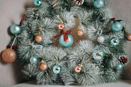 Traditional Christmas decorative wreath over grey marble wall. Holiday interior details. Round fir garland with snow, blue glitter balls and pine cones. New Year mood.の写真素材