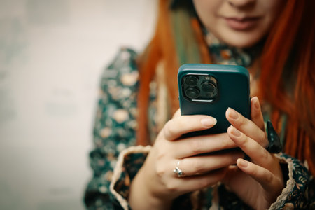 Blogger holds iPhone 13 pro and looks at smartphone screen. Mobile phone in womens hands. Photos for advertising apps and gadgets with copy space. Bishkek, Kyrgyzstan - January 24, 2022のeditorial素材